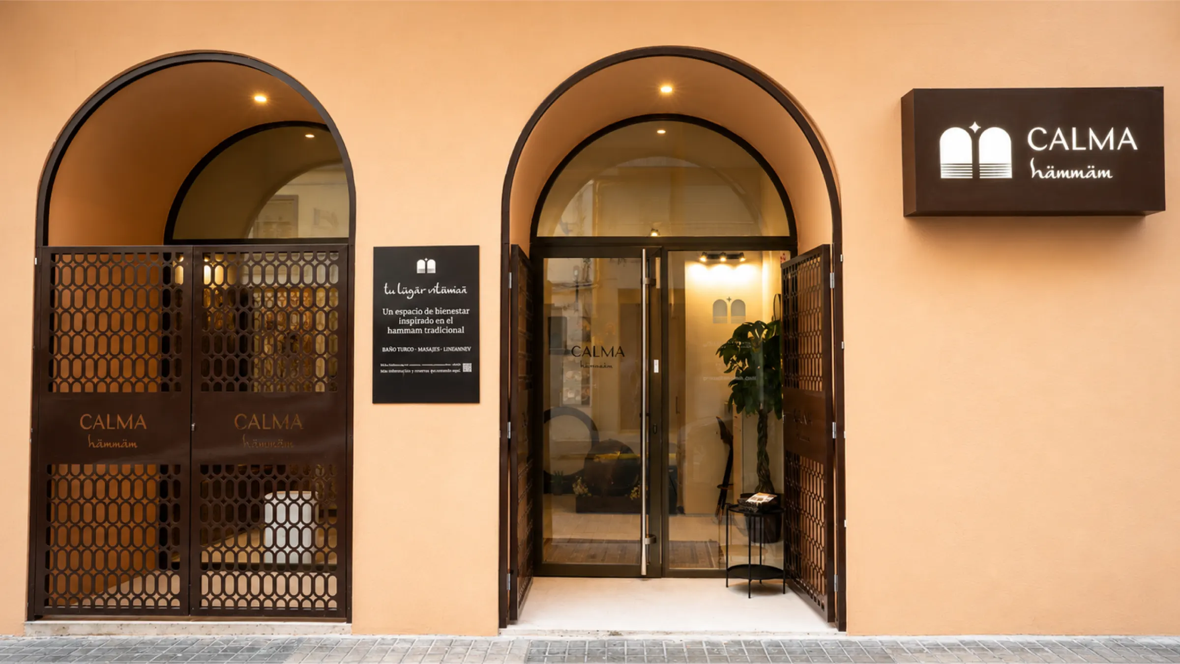 Fachada de Calma Hammam con sus dos arcos, celosías y rótulo luminoso