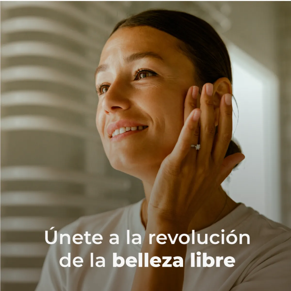 Mujer sonriendo con la mano en la mejilla y el mensaje «Únete a la revolución de la belleza libre»